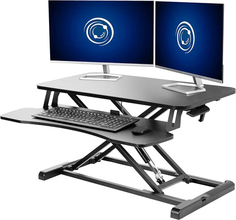 Standing desk converter holding two monitors